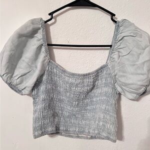 Light blue crop top with slightly puffed sleeves.